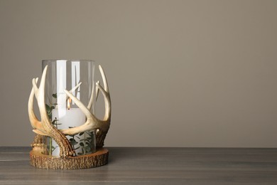 Photo of Burning candles in beautiful holder on wooden table, space for text