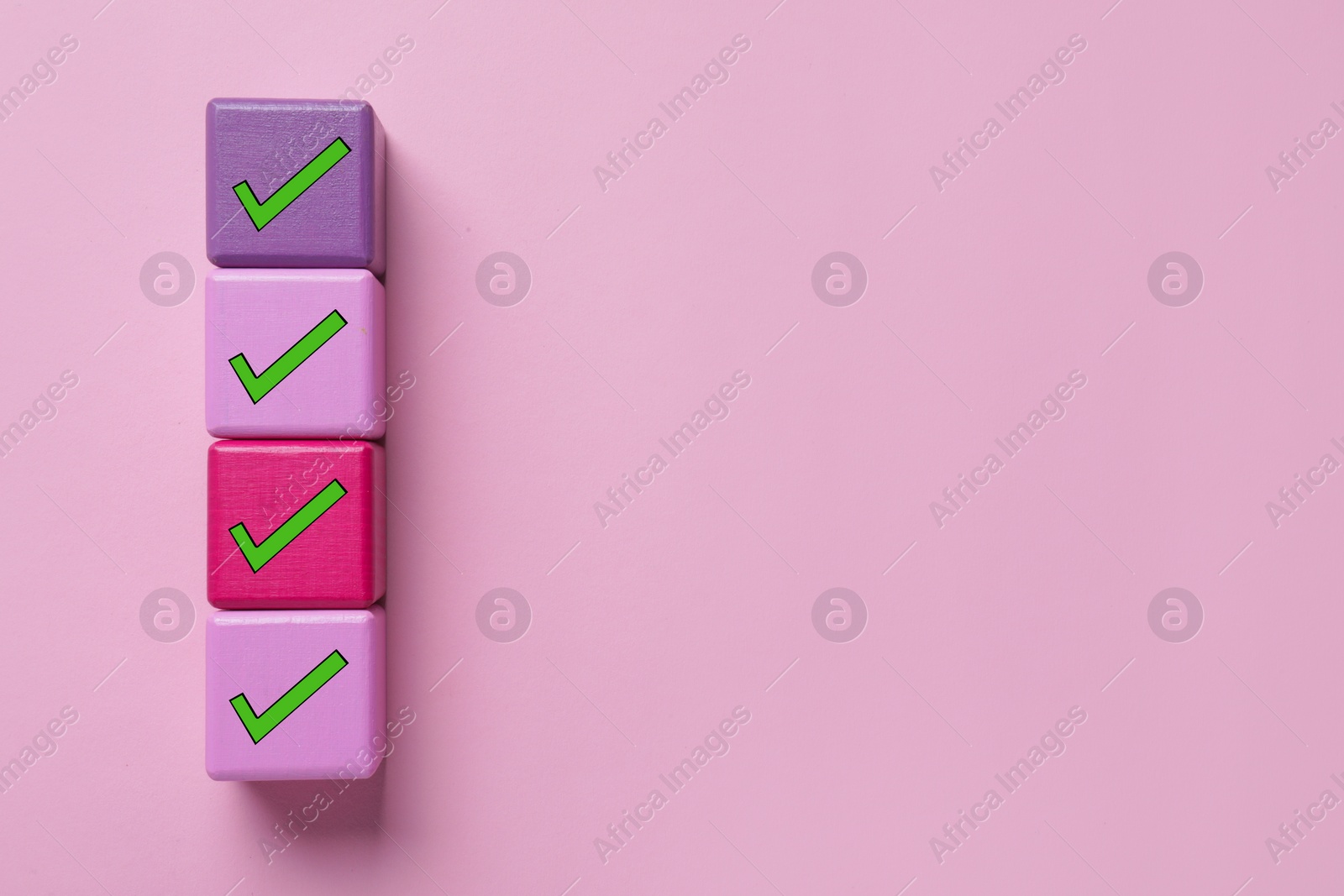 Image of Cubes with check marks on pink background, top view. Space for text