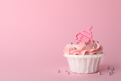 Photo of Baby shower cupcake with topper on pink background, space for text