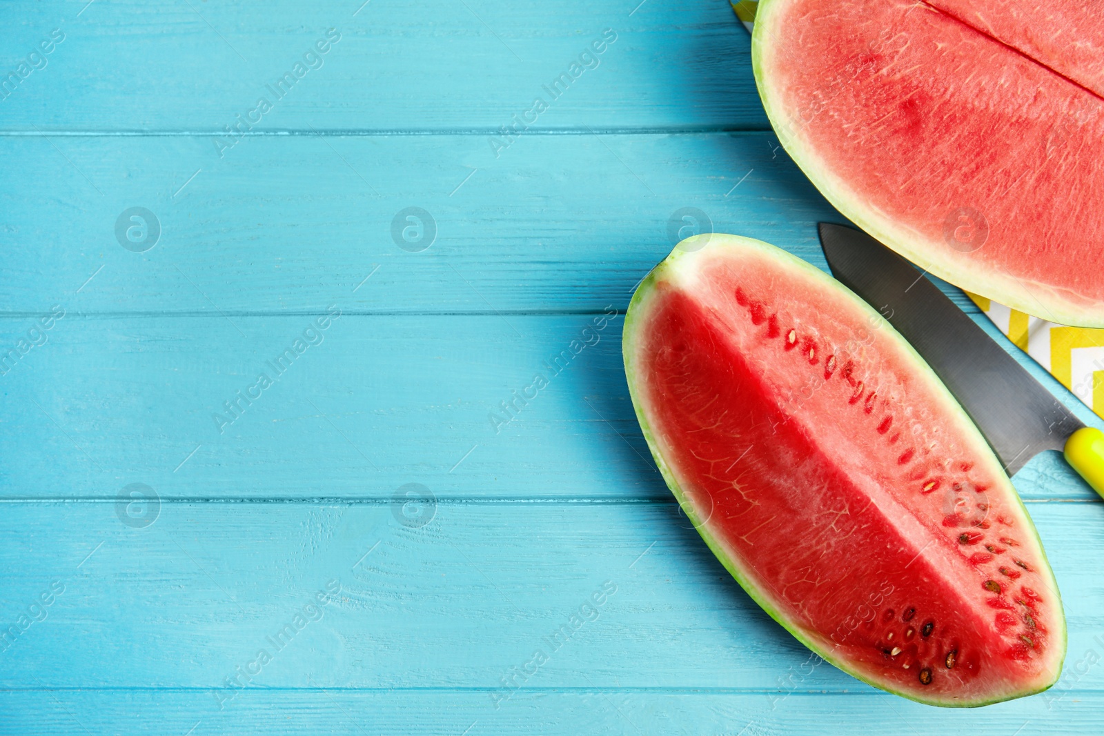 Photo of Yummy cut watermelon on light blue wooden table, flat lay. Space for text