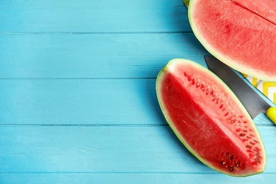 Photo of Yummy cut watermelon on light blue wooden table, flat lay. Space for text