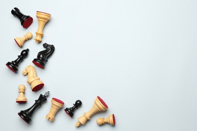 Photo of Many different chess pieces on white background, flat lay. Space for text