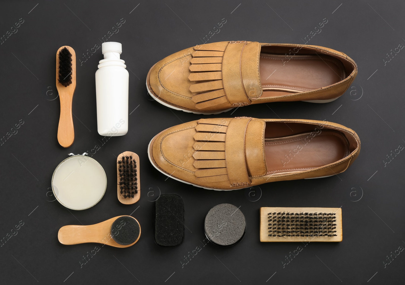 Photo of Flat lay composition with shoe care accessories and footwear on black background