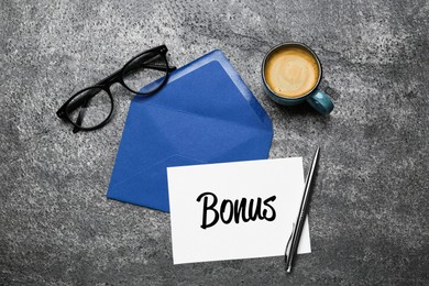 Image of Blue envelope, letter with word Bonus, coffee and eyeglasses on grey table, flat lay