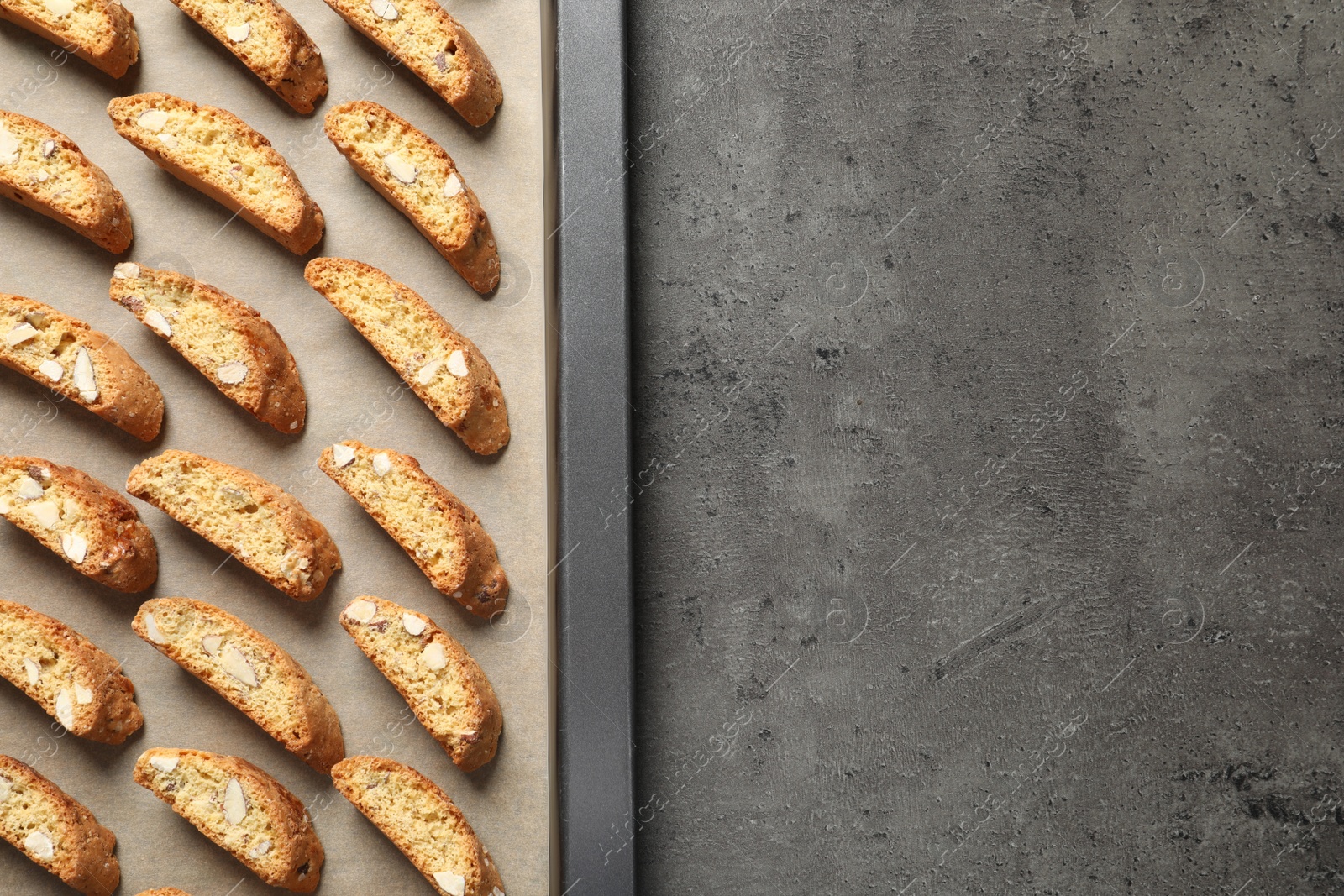 Photo of Traditional Italian almond biscuits (Cantucci) on grey table, top view. Space for text