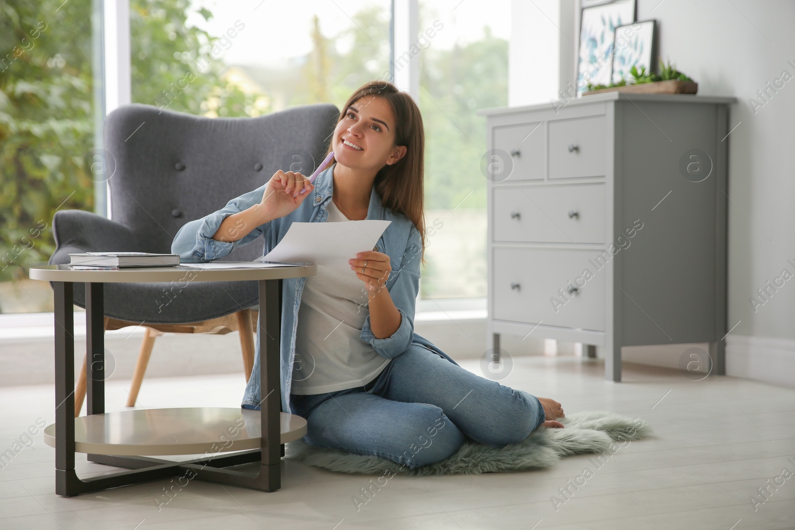 Photo of Woman writing paper letter at table indoors