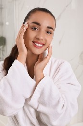 Photo of Beautiful young woman with perfect skin in bathroom. Facial wash