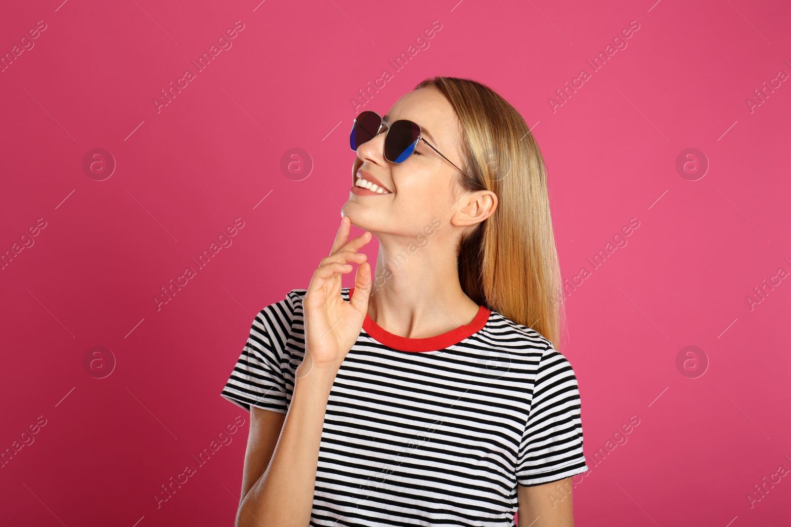 Photo of Beautiful woman in stylish sunglasses on pink background