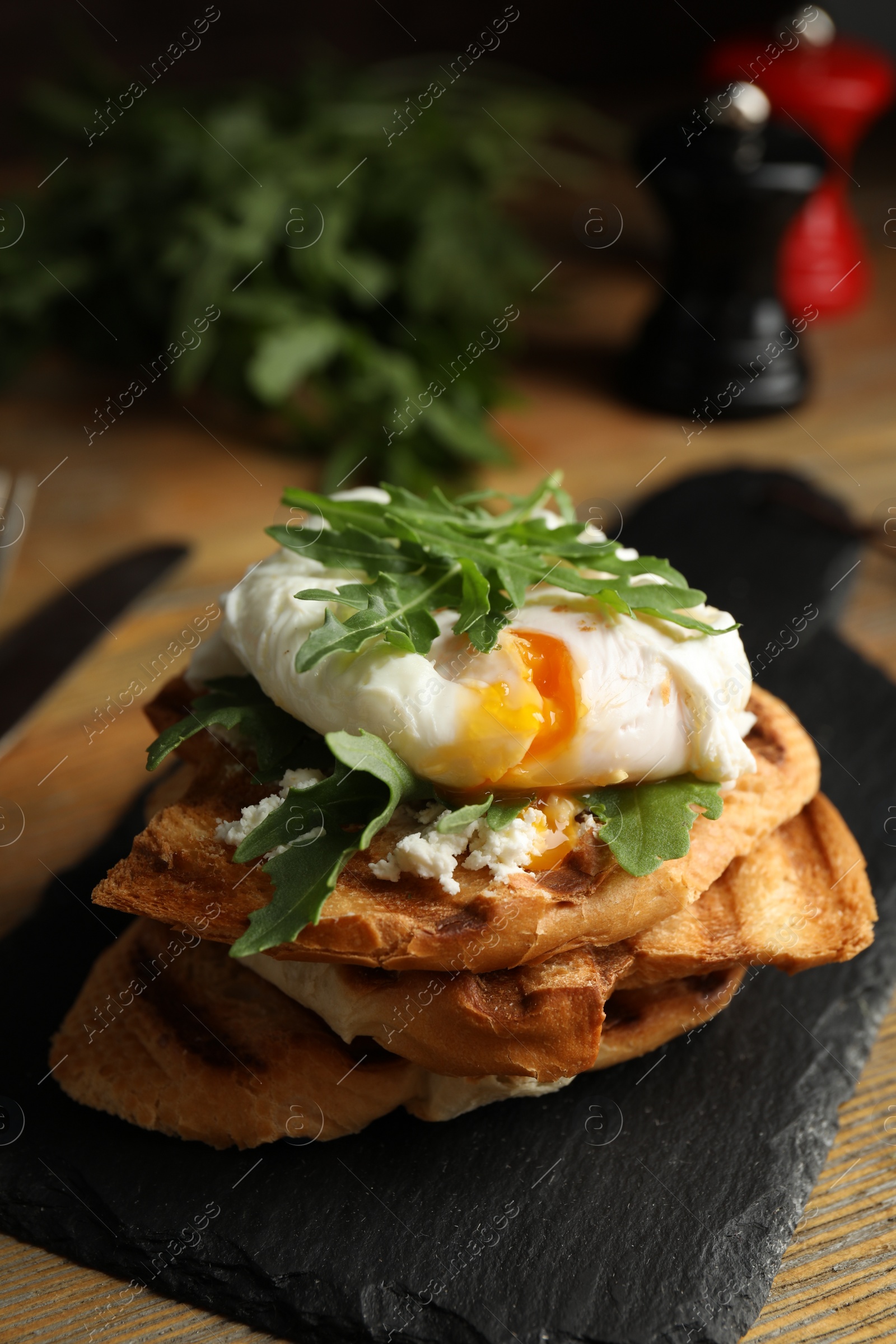 Photo of Delicious sandwich with arugula and egg on wooden table, closeup