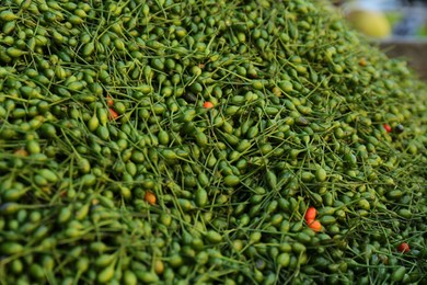 Photo of Heap of fresh delicious chiltepin at market, closeup