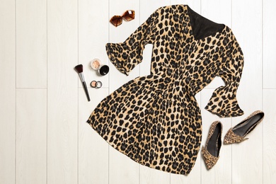Photo of Flat lay composition with stylish leopard print dress on wooden floor