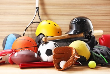 Photo of Many different sports equipment on wooden table