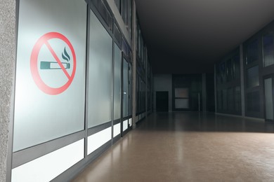 Image of Sign No Smoking drawn on glass wall in office corridor