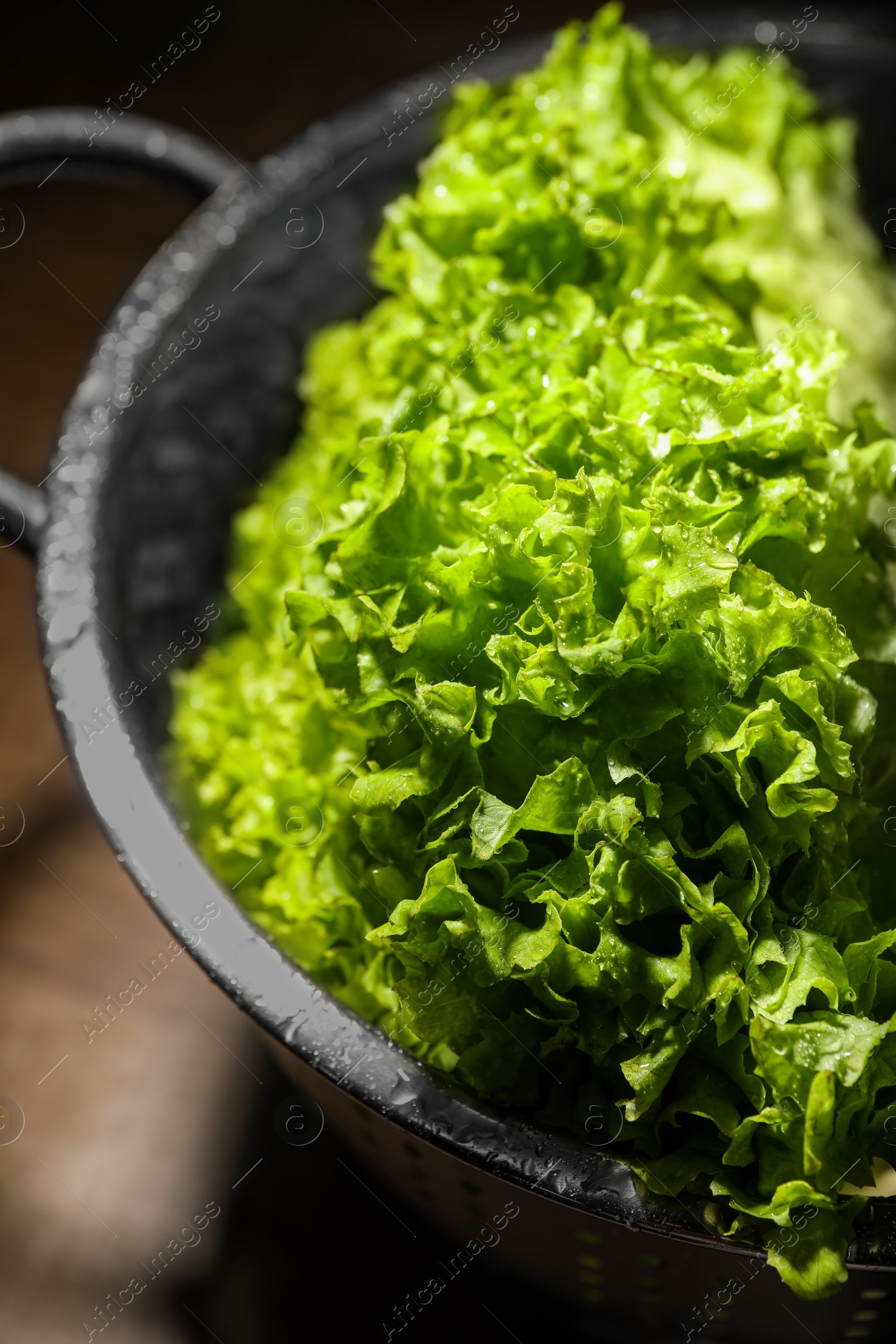 Photo of Fresh lettuce on brown table, closeup. Salad greens