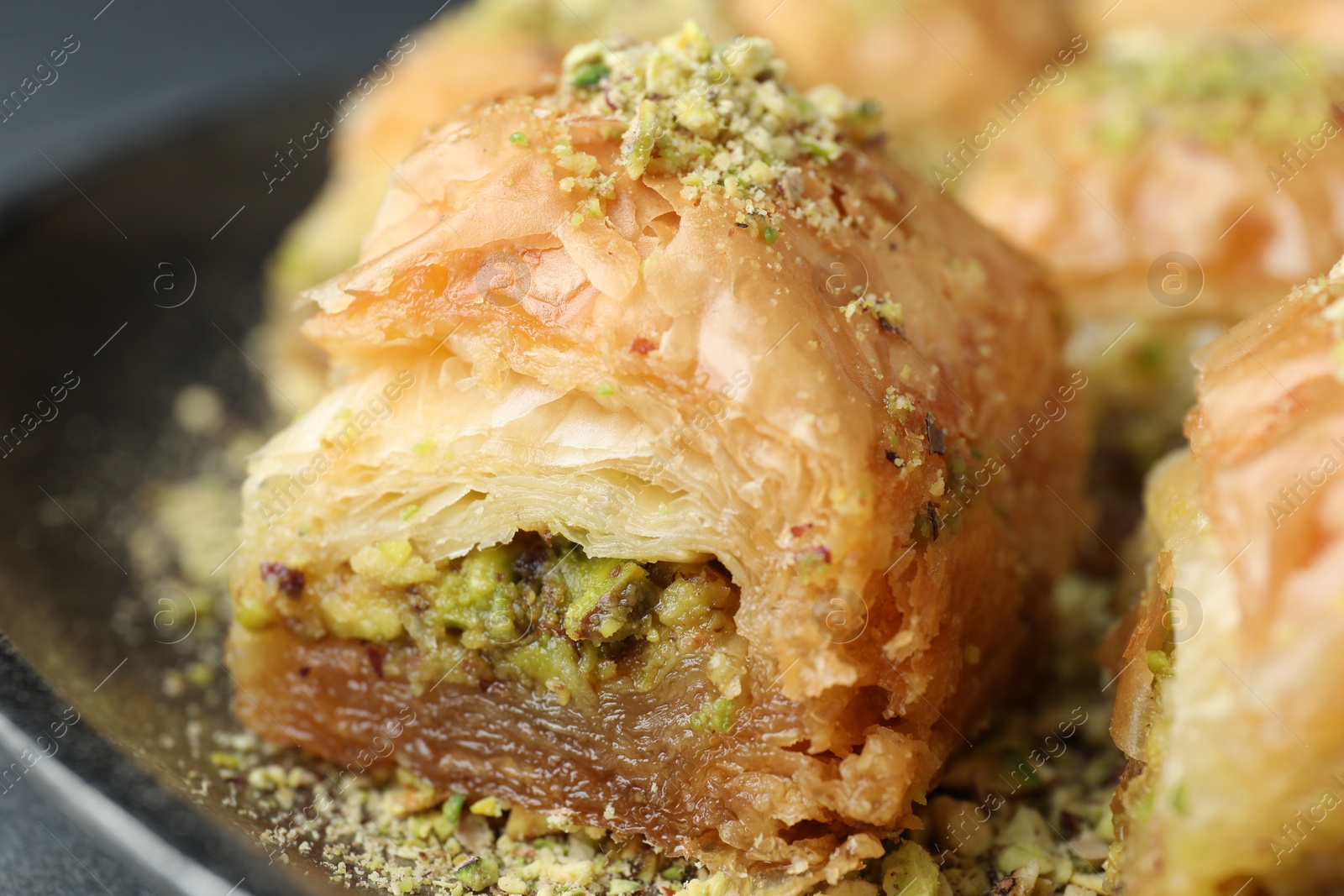 Photo of Delicious fresh baklava with chopped nuts on plate, closeup. Eastern sweets