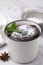 Photo of Tasty powdered chocolate mug pie on white marble table, closeup. Microwave cake recipe