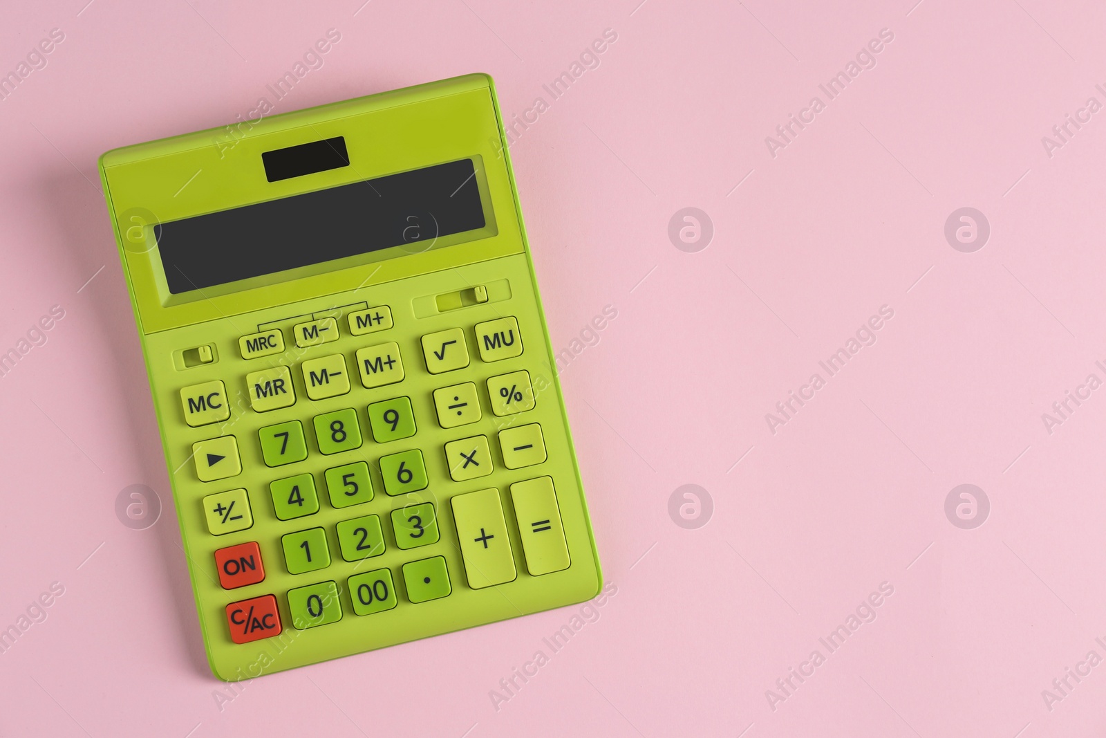 Photo of Green calculator on pink background, top view. Space for text