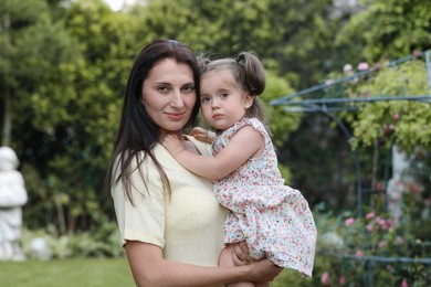 Mother with her cute daughter spending time together in park