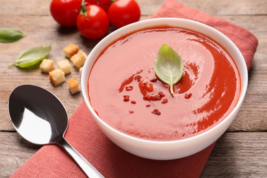 Bowl with fresh homemade tomato soup on wooden table