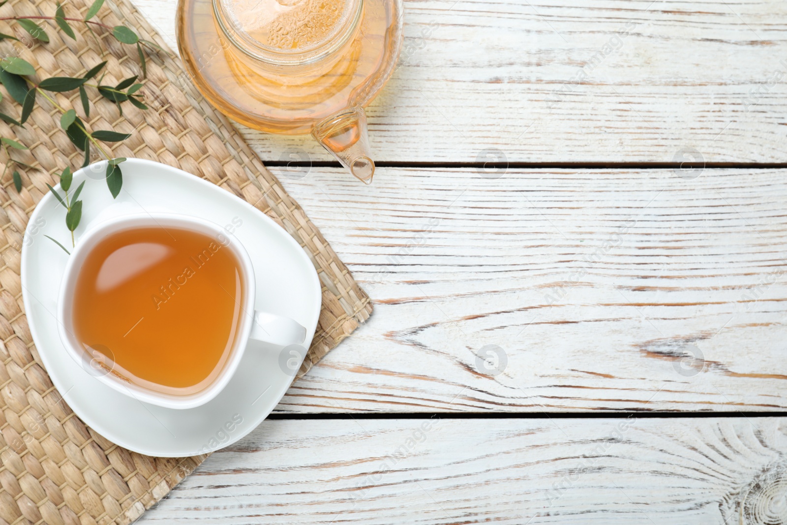 Photo of Aromatic eucalyptus tea on white wooden table, flat lay. Space for text