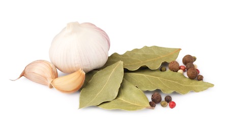 Photo of Aromatic bay leaves, garlic and peppercorns on white background