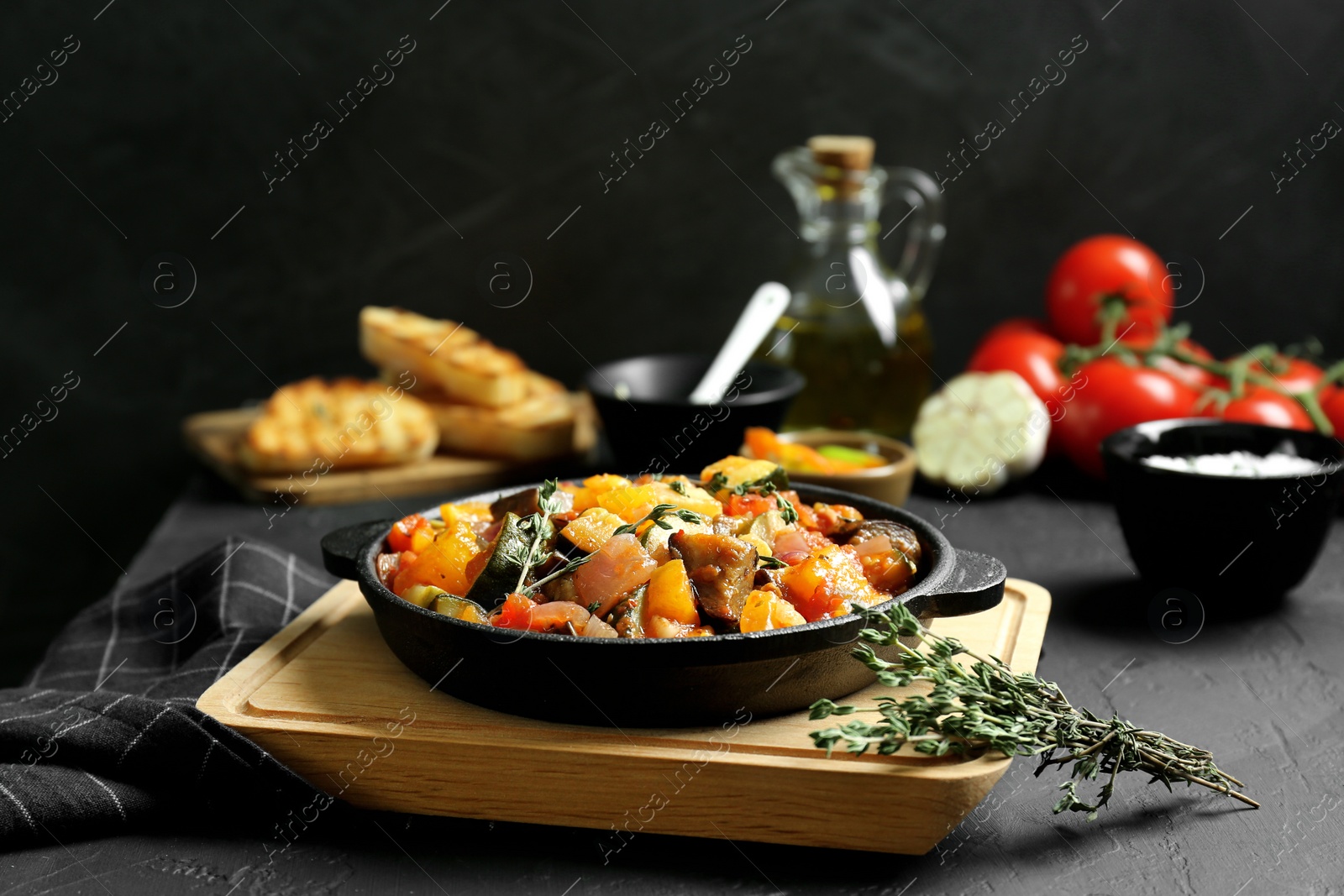 Photo of Dish with tasty ratatouille on black table