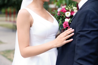 Newlyweds with beautiful bridal bouquet outdoors, closeup