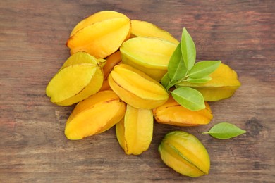 Photo of Delicious ripe carambolas on wooden table, flat lay