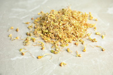 Photo of Heap of sprouted green buckwheat on light table, closeup