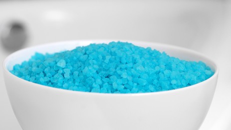 Photo of White bowl with light blue bath salt, closeup