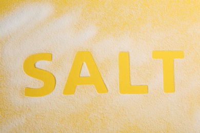 Photo of Word SALT on yellow background, top view