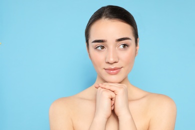 Portrait of young woman with beautiful face against color background