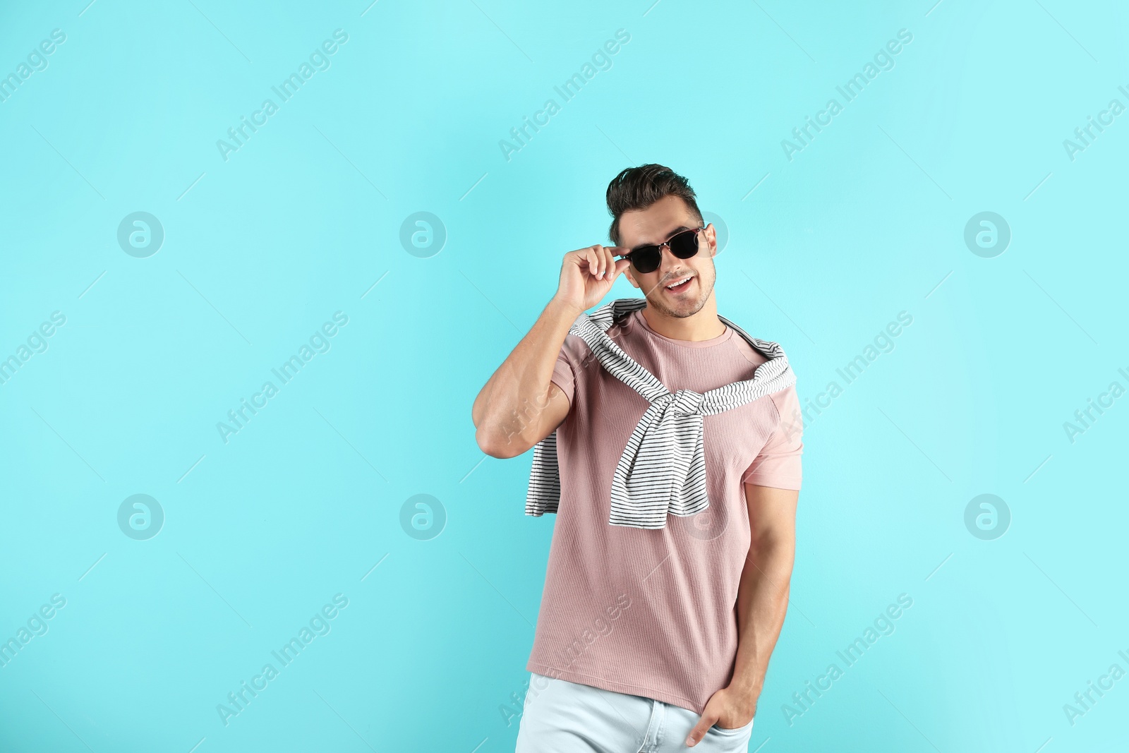 Photo of Young man in stylish jeans on color background