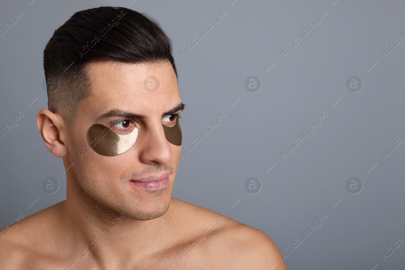 Photo of Man with dark under eye patches on grey background. Space for text