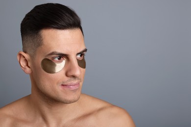 Man with dark under eye patches on grey background. Space for text