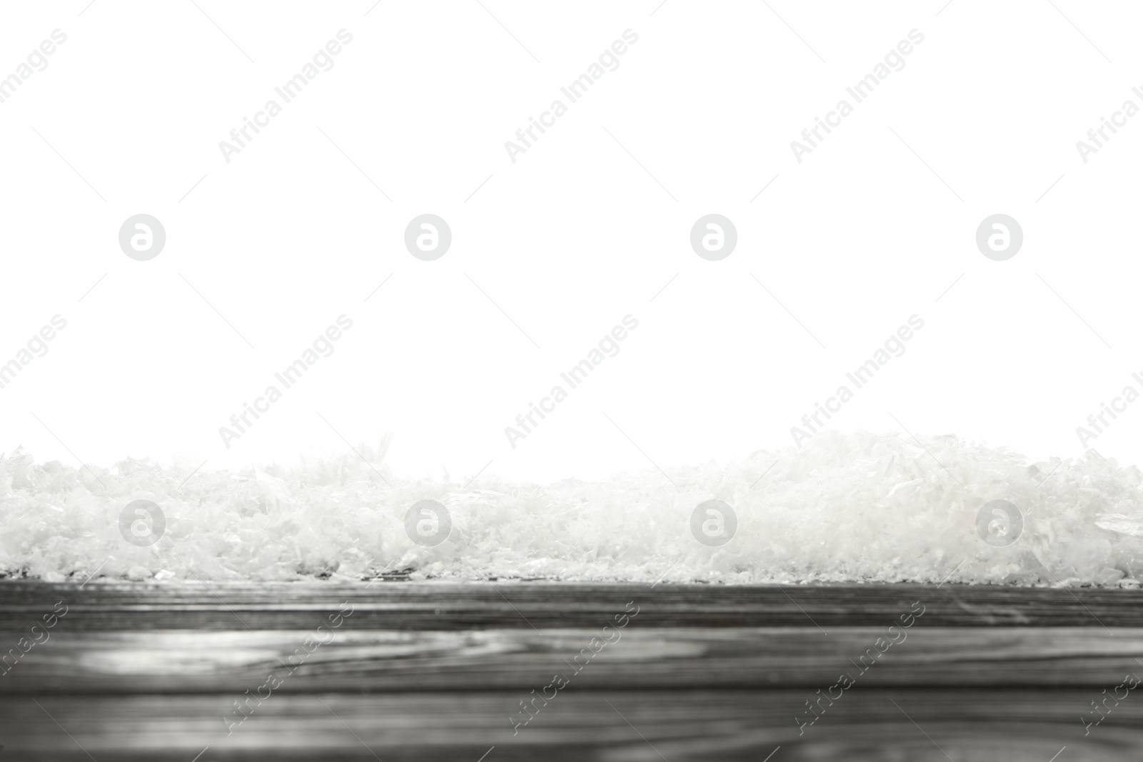 Photo of Snow on black wooden surface against white background. Christmas season