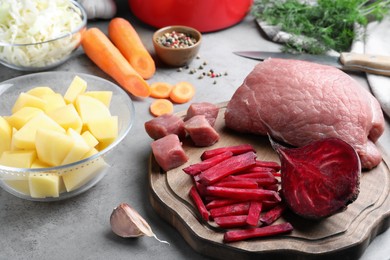 Photo of Fresh ingredients for borscht on grey table