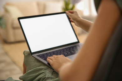 Photo of Woman using laptop at home, closeup. Space for design