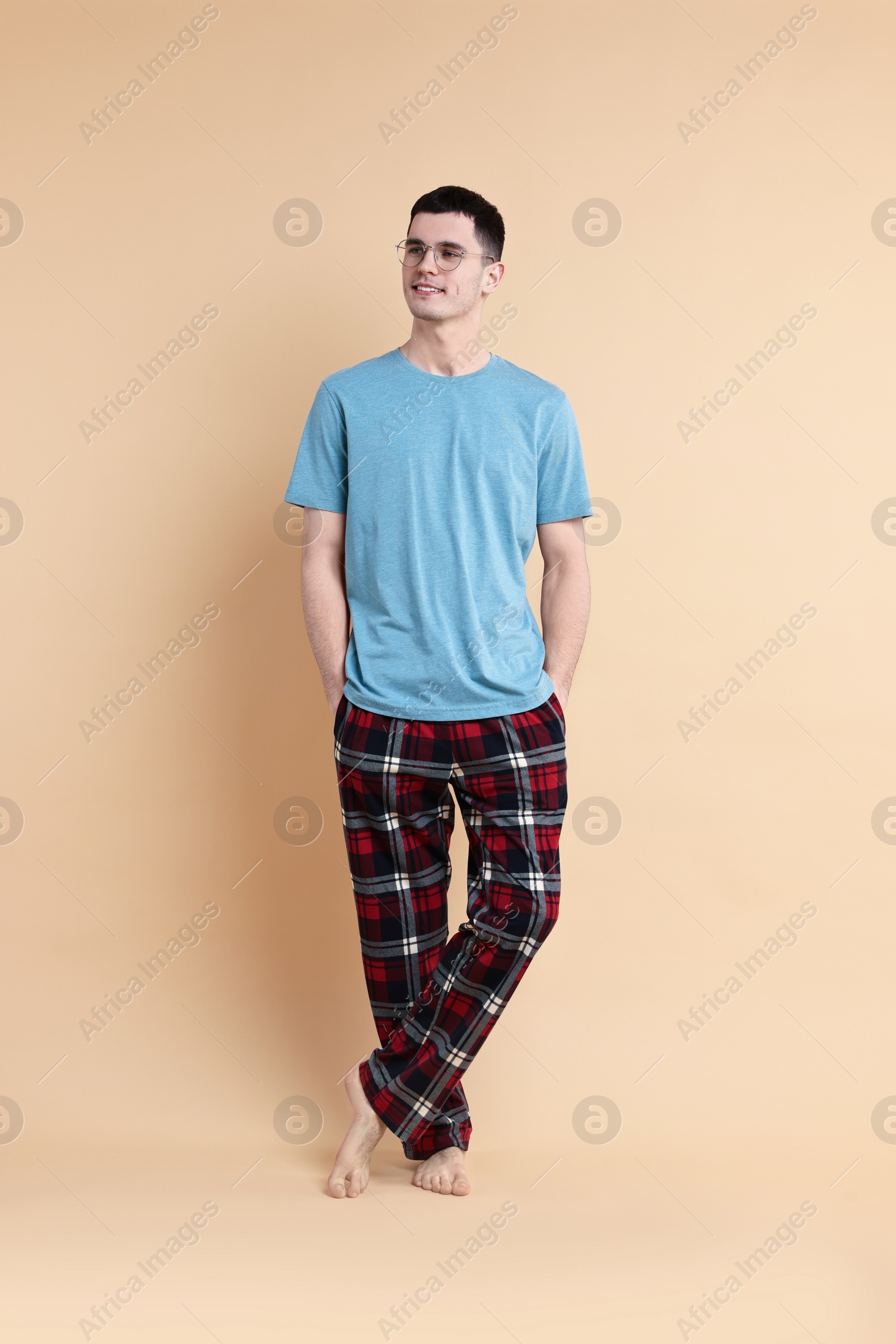 Photo of Happy man in pyjama on beige background