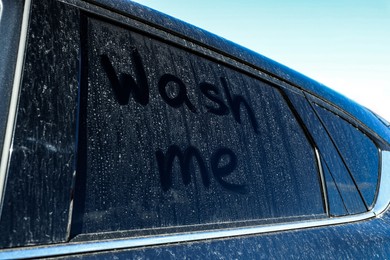 Photo of Inscription Wash me on dirty car window, closeup