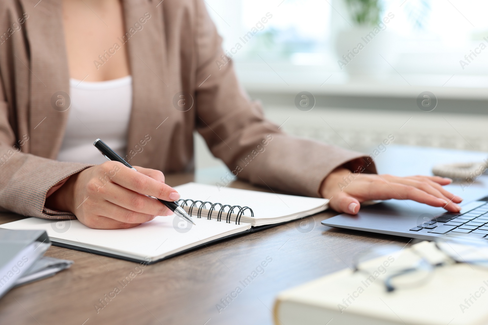 Photo of Secretary working at table in office, closeup