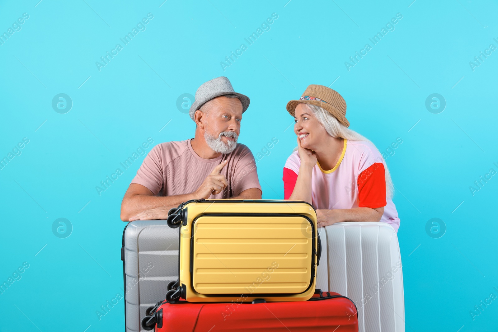 Photo of Senior couple with suitcases on color background. Vacation travel