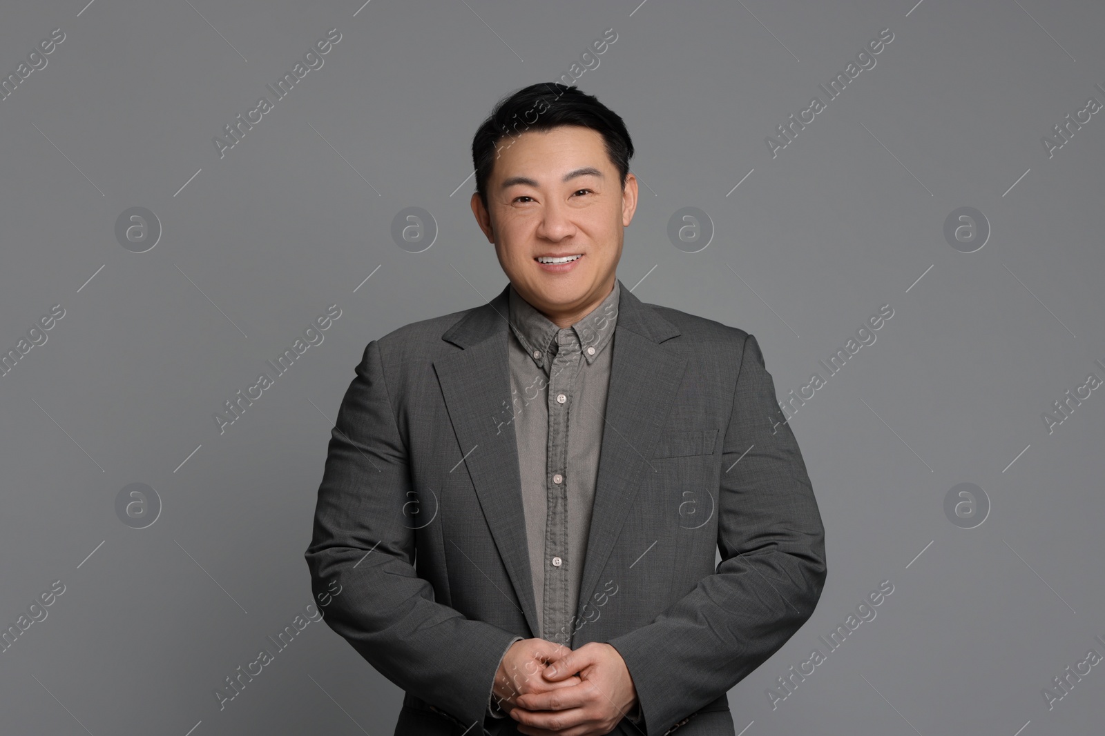 Photo of Portrait of happy businessman on grey background