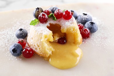 Photo of Tasty vanilla fondant with white chocolate and berries on white table, closeup