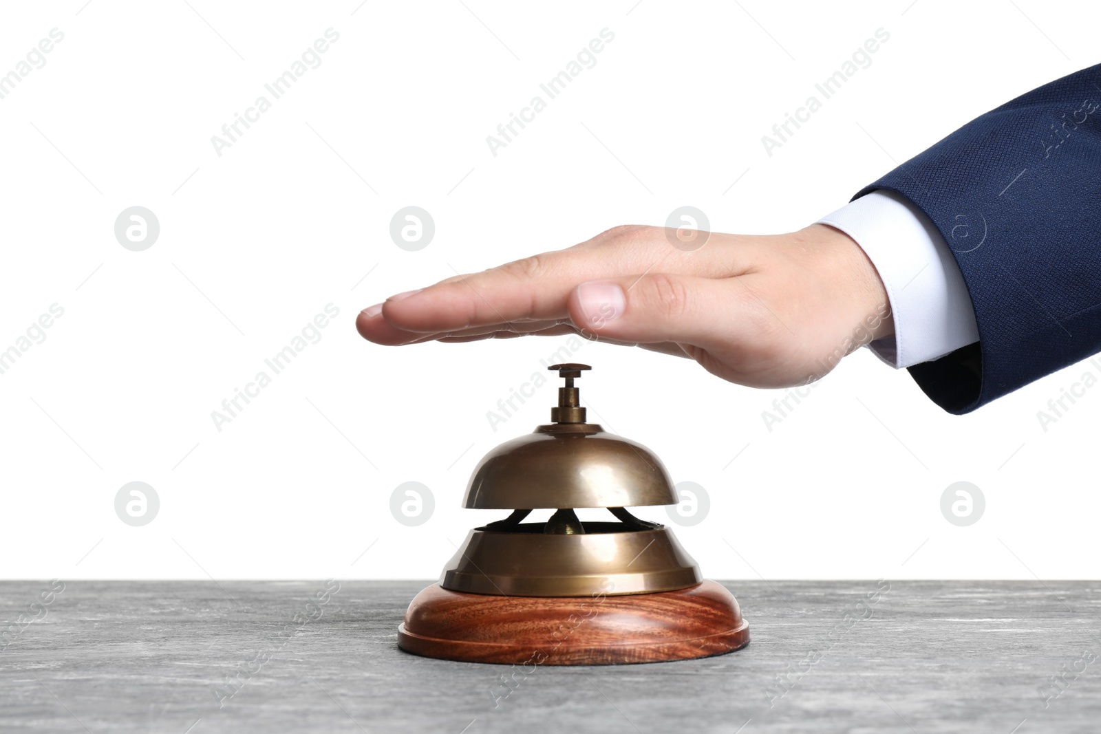 Photo of Man ringing hotel service bell at grey stone table