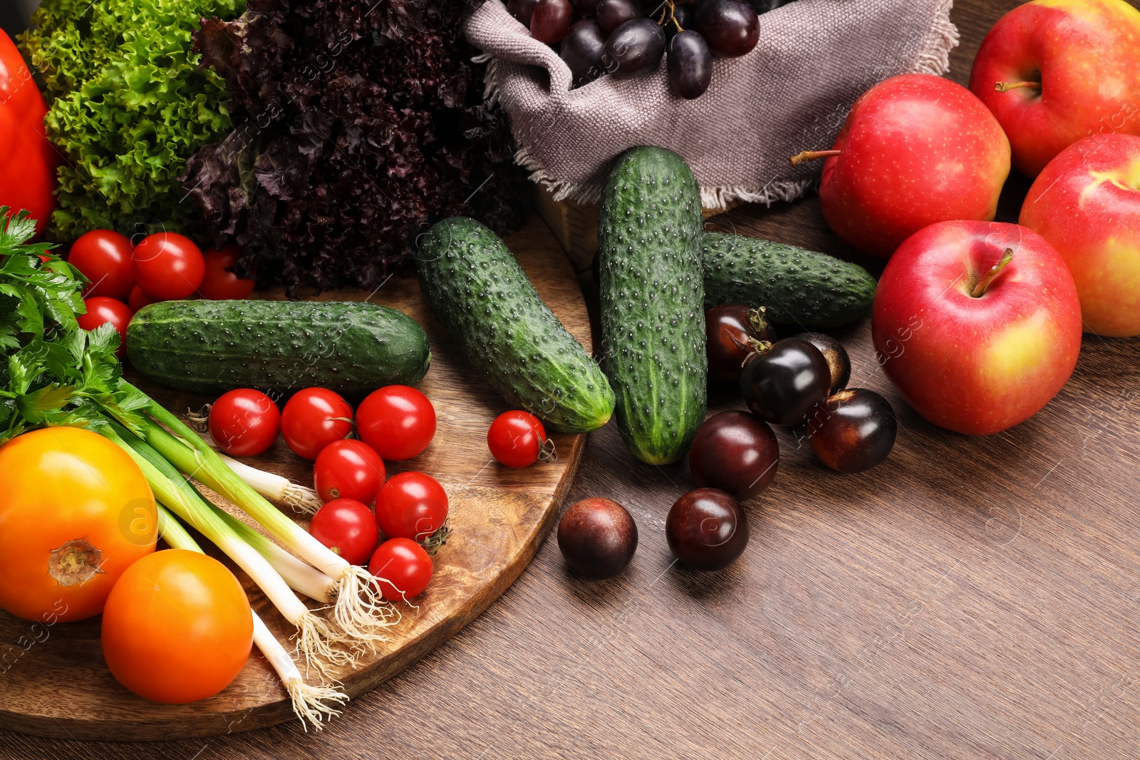 Photo of Different fresh ripe vegetables and fruits on wooden table, closeup