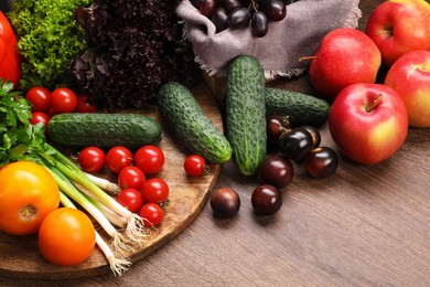 Photo of Different fresh ripe vegetables and fruits on wooden table, closeup