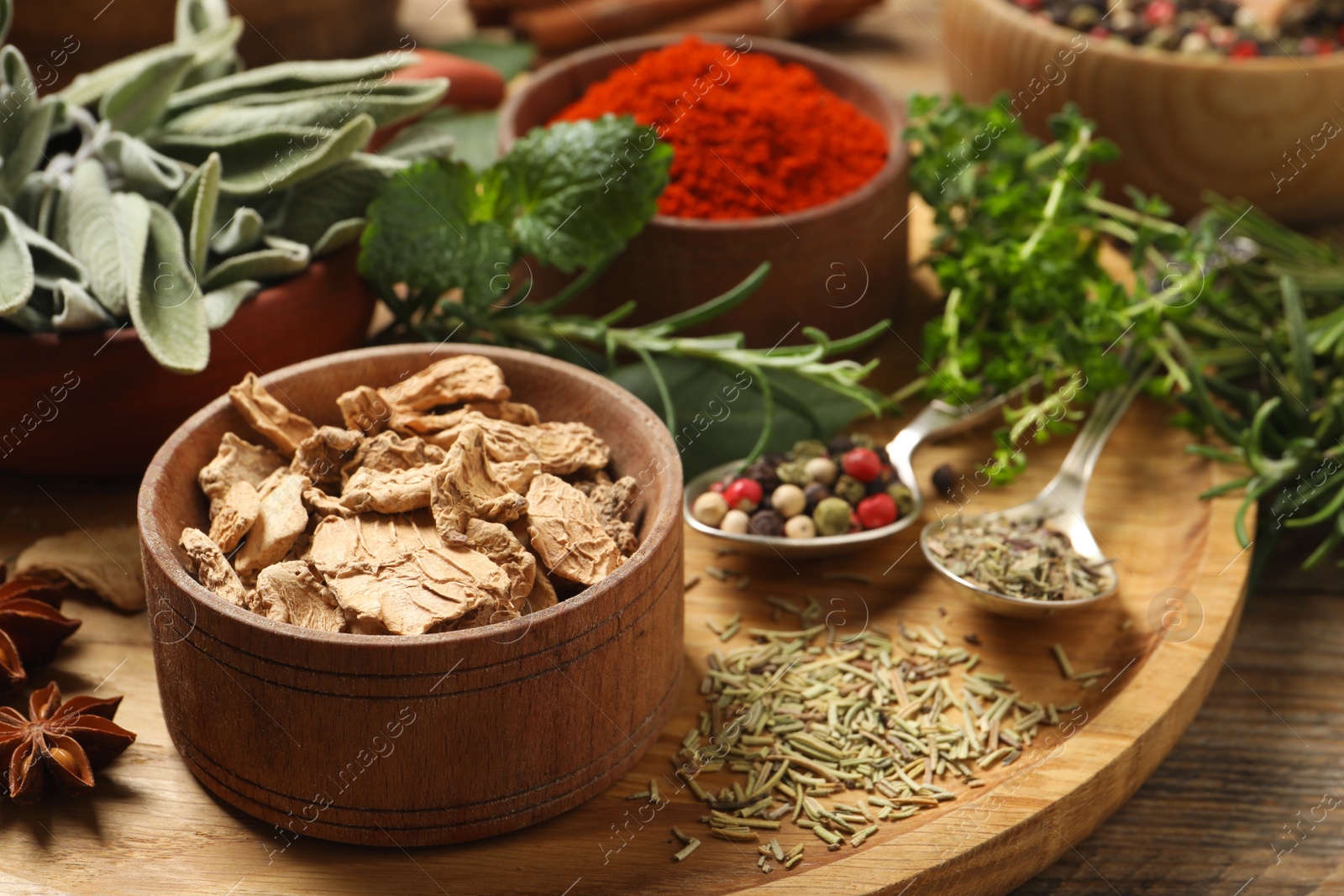 Photo of Different herbs and spices on wooden table, closeup