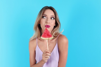 Photo of Pretty young woman with juicy watermelon on color background