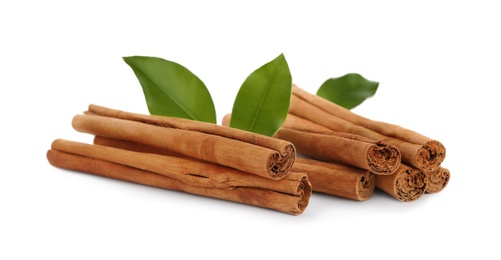 Photo of Aromatic dry cinnamon sticks and green leaves on white background